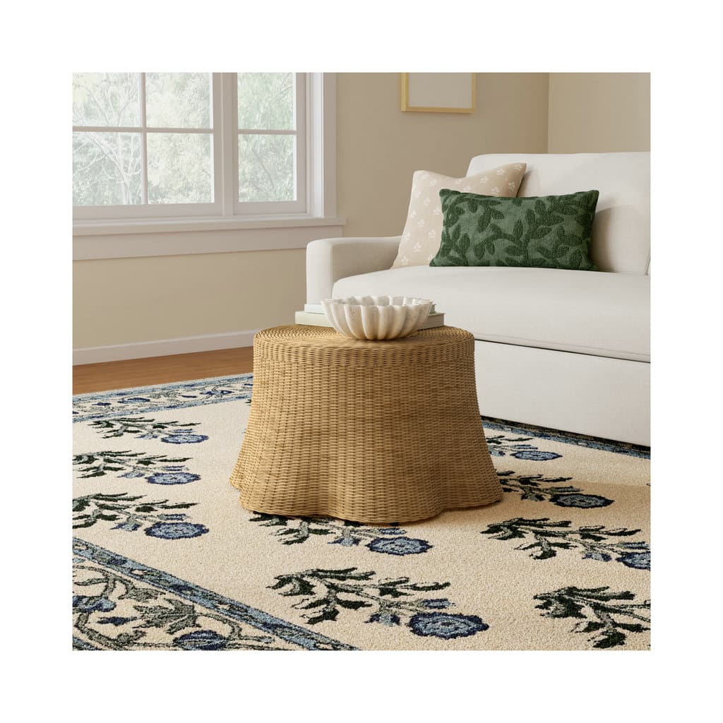 A round rattan coffee table styled in a warm, beige-toned living room