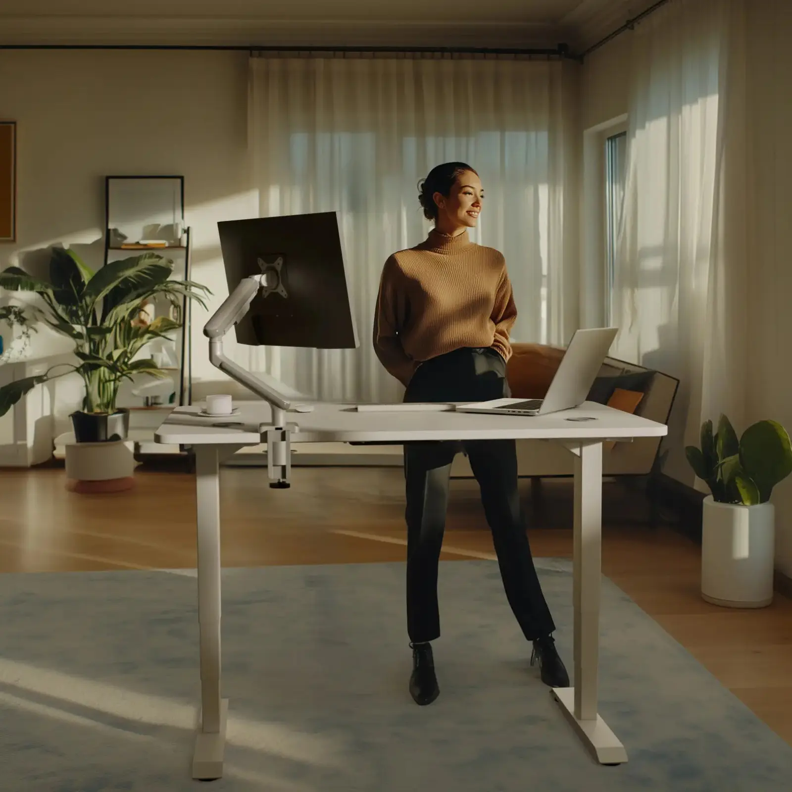 The desk with a white frame and a white top at standing height, a monitor arm clamped to the back edge (monitor, arm and laptop not included)