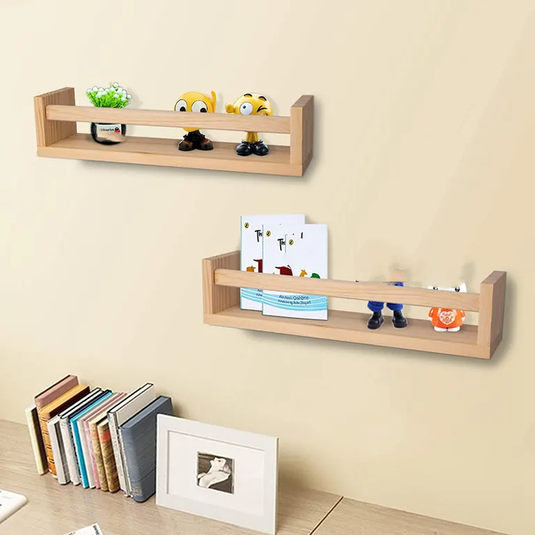 Two natural wood wall shelves holding books and small figures above a desk