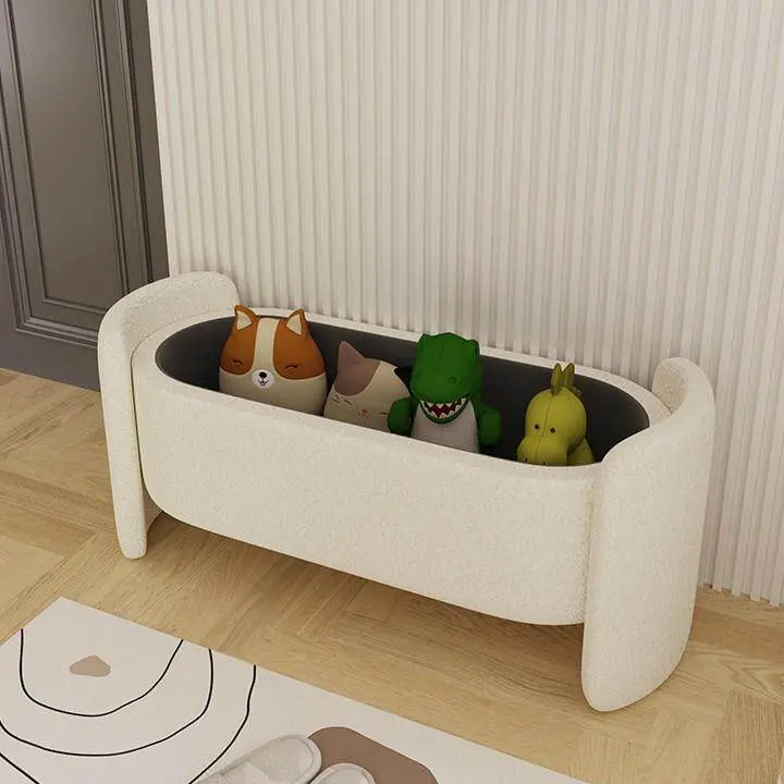 The bench with its lid off, showing the dark-lined storage compartment holding soft toys (toys, rug and slippers not included)