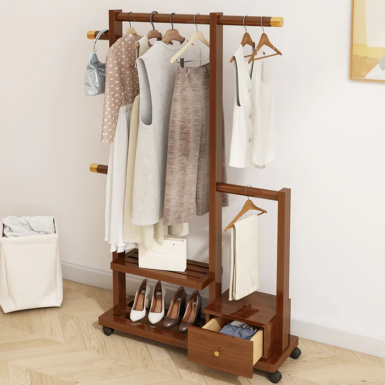Dark wood clothes rack with its drawer open, holding clothes and shoes, beside a laundry basket